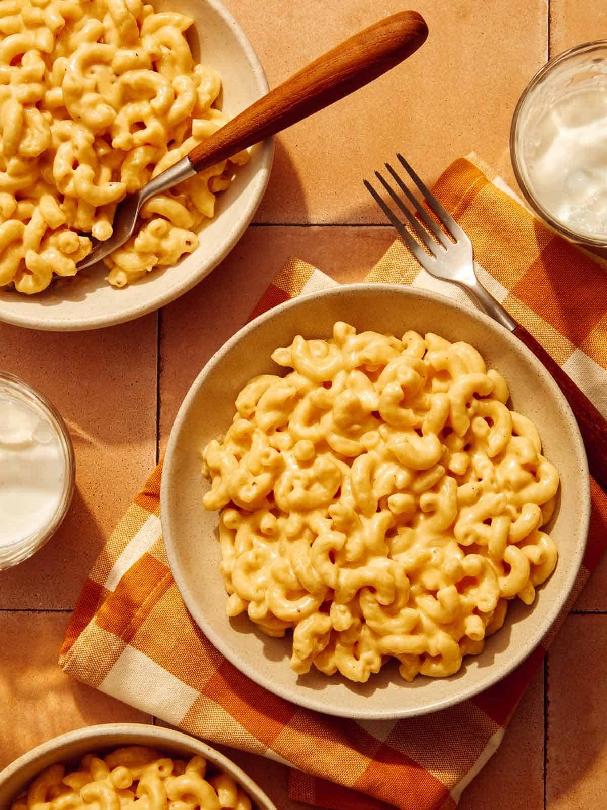 Three bowls of mac and cheese made in a crock pot.