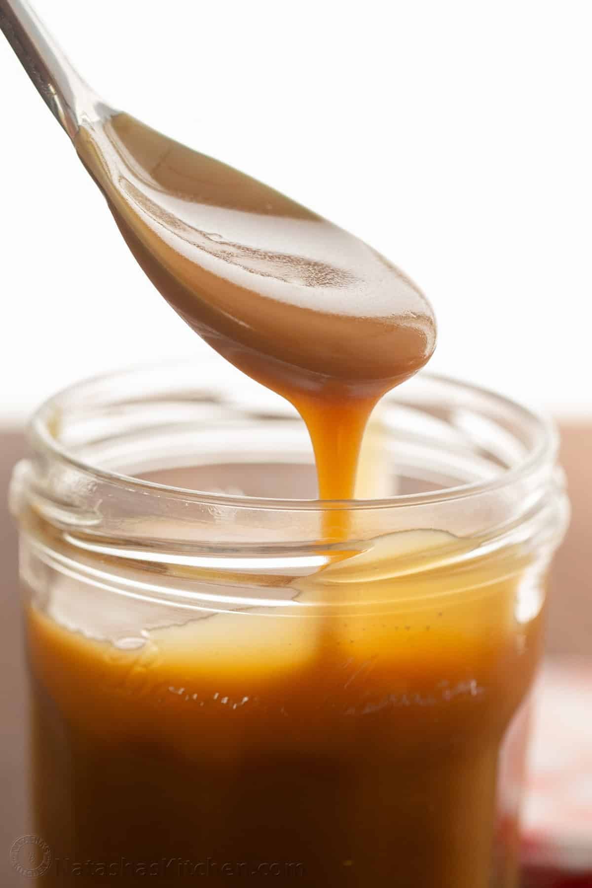 Scooping homemade butterscotch sauce using a spoon