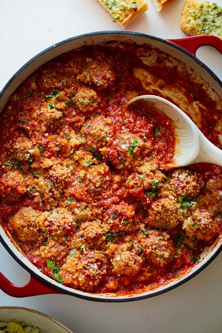 Ricotta meatballs in red sauce in a pan.
