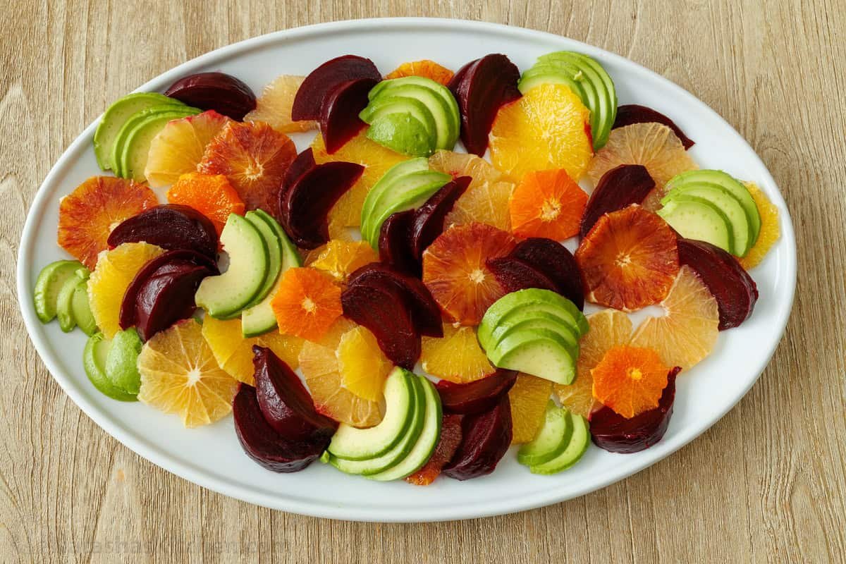 Citrus Salad looks so beautiful with fresh, colorful fruit and tastes amazing drizzled with sweetened lemon vinaigrette! Holiday-worthy dish. Easy citrus salad on an oval plate with grapefruit, orange, tangerine, beets, and avocado