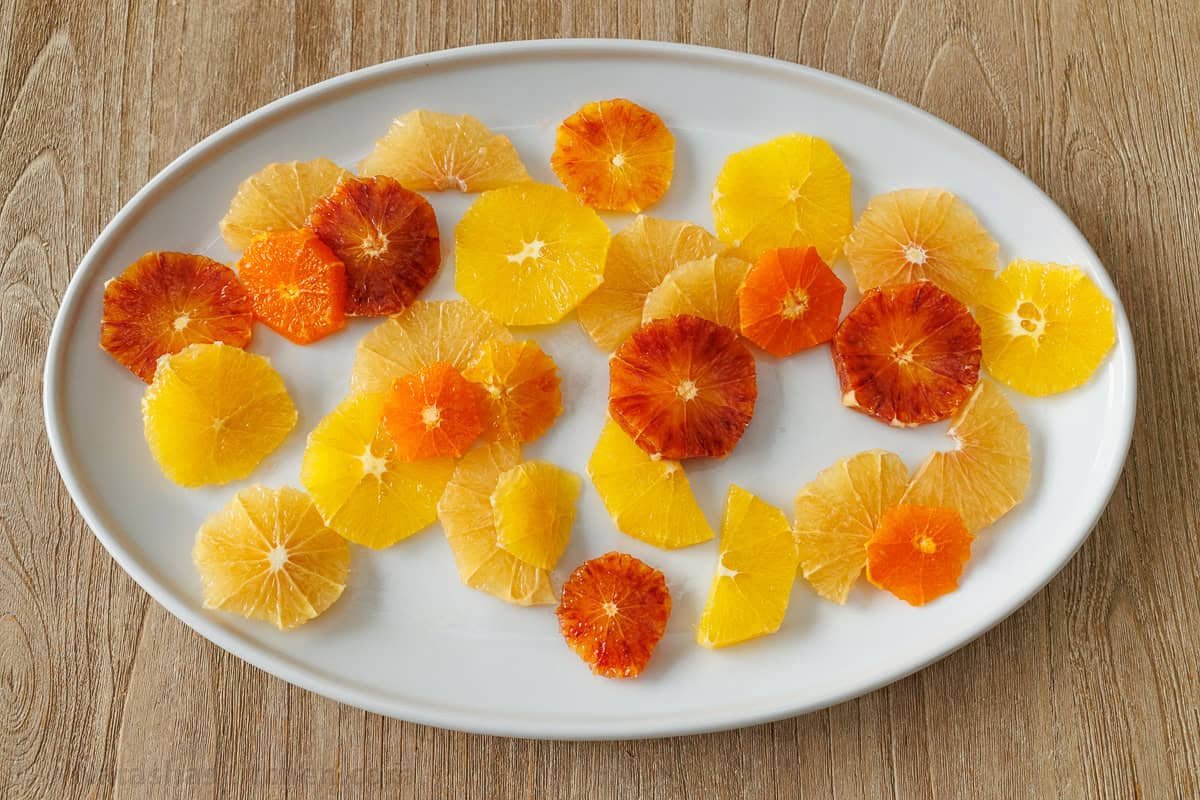 Orange, grapefruit and blood orange slices on a white oval plate