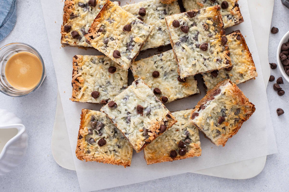 Overhead view of magic bars cut into squares and arranged on a piece of parchment paper.