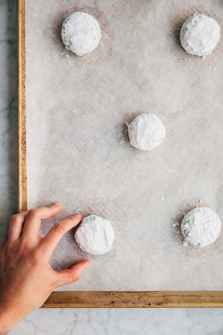 Photo of Michelle from Hummingbird High placing the prepared pandan cookie dough ball on a sheet pan in a hopscotch formation