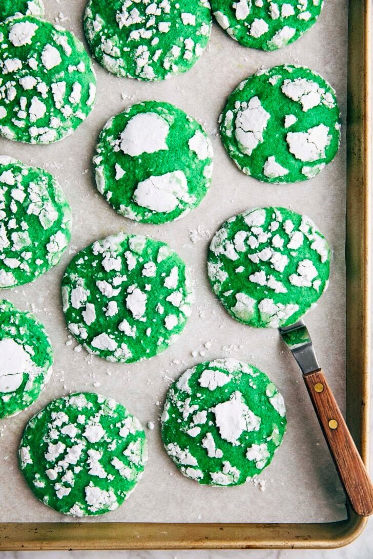 Photo of vibrant green pandan crinkle cookies on a gold sheet pan