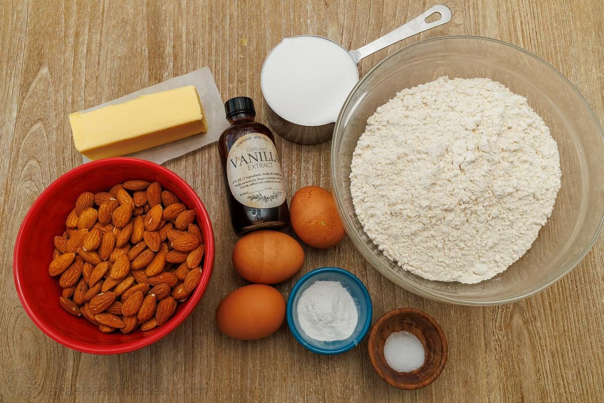 Ingredients for easy breakfast cookies for dipping in coffee, including almonds, butter, vanilla extract, sugar, eggs, salt, flour and baking soda