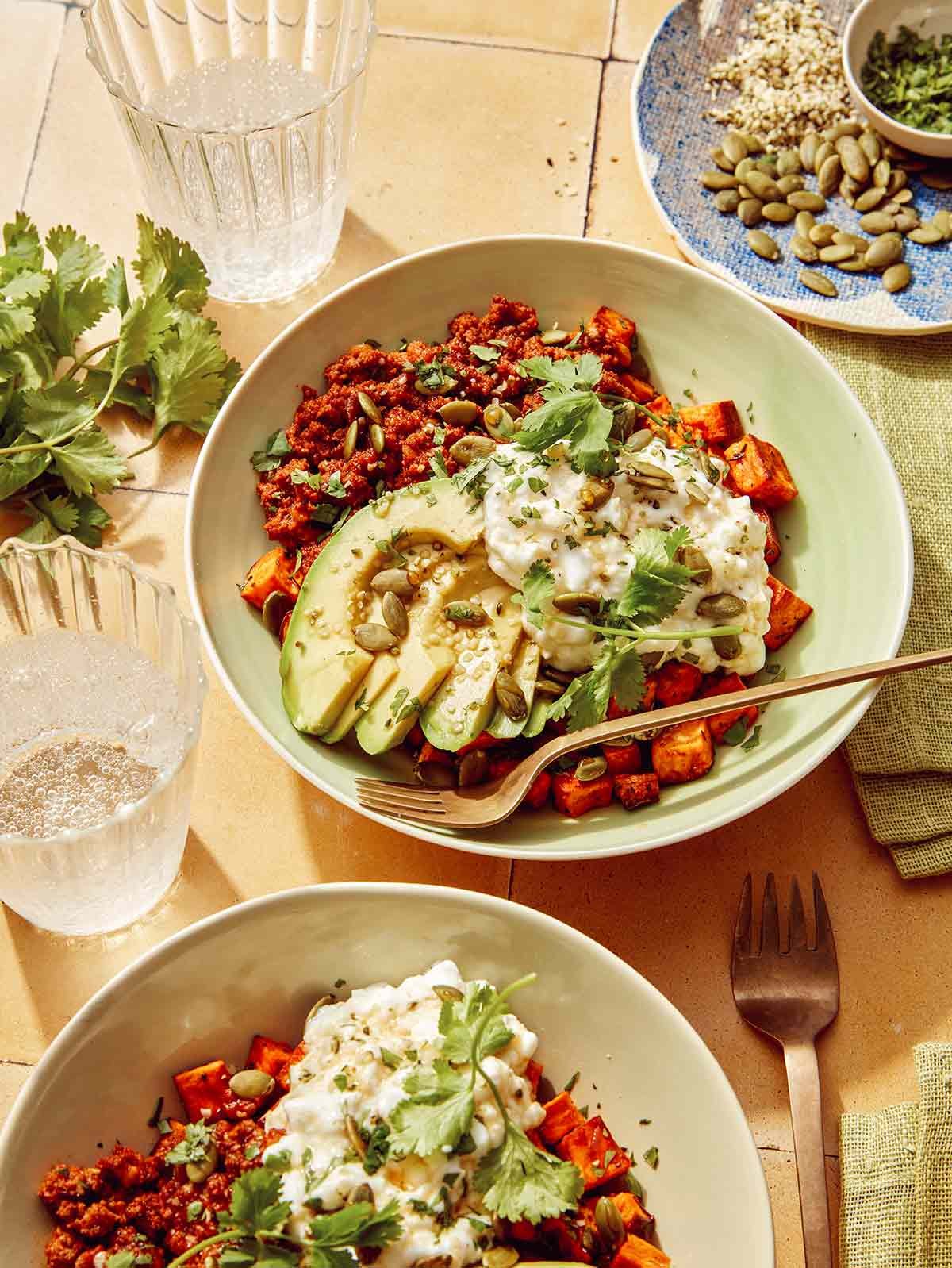 Beef protein bowls on a kitchen counter with water on the side.