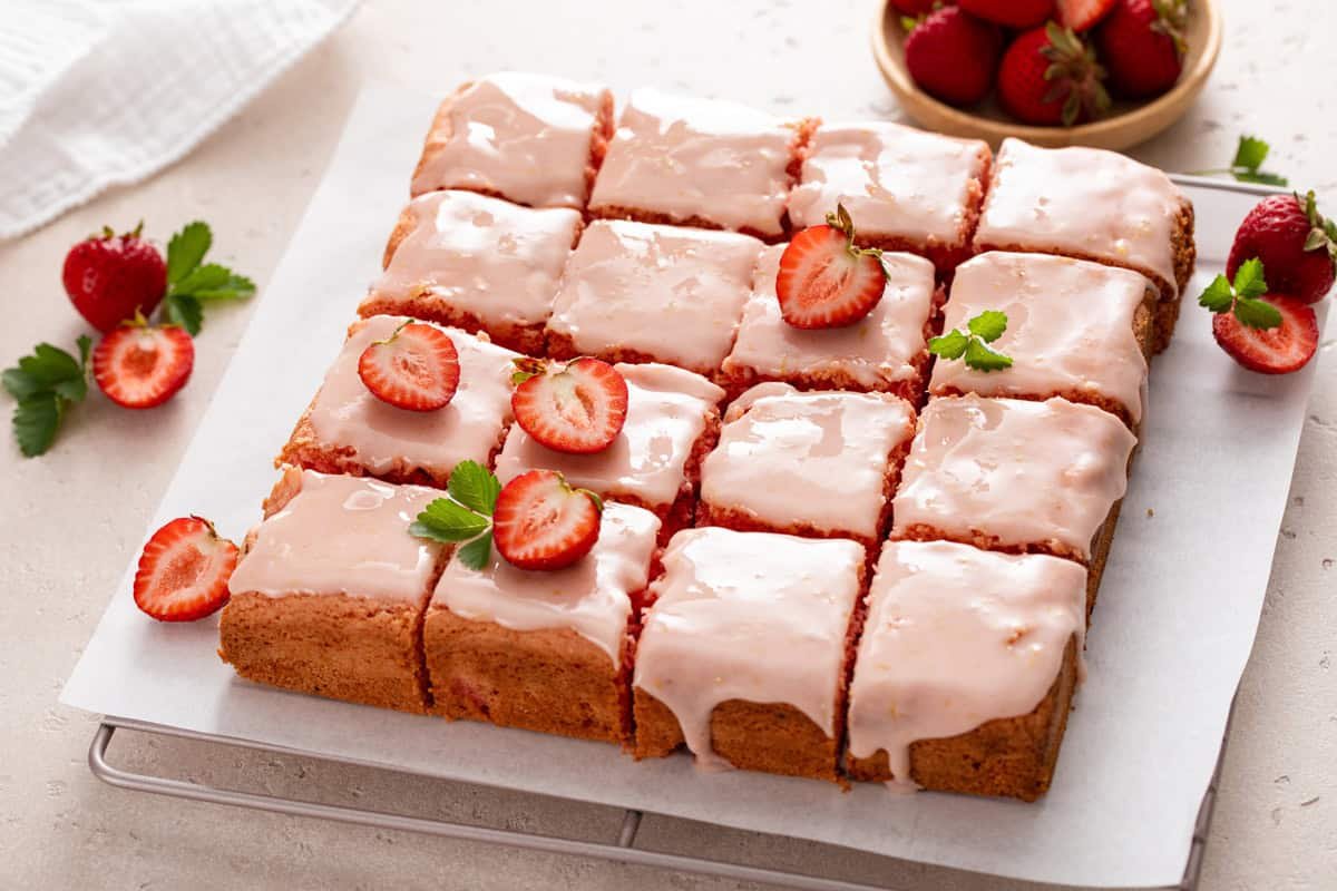 Sliced pan of strawberry brownies on a piece of parchment paper.