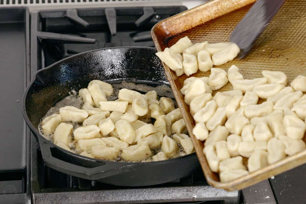 Easy Ricotta Gnocchi makes classic Italian dumplings sautéed in bacon butter for irresistible crispy edges. Make-ahead and Freezer-friendly! Adding Italian Dumplings to a saute pan with bacon butter