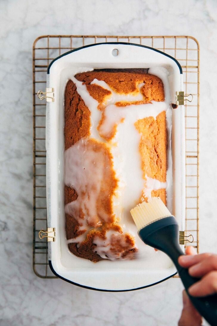 Photo of Michelle from Hummingbird High using a pastry brush to spread the lemon glaze over the cake