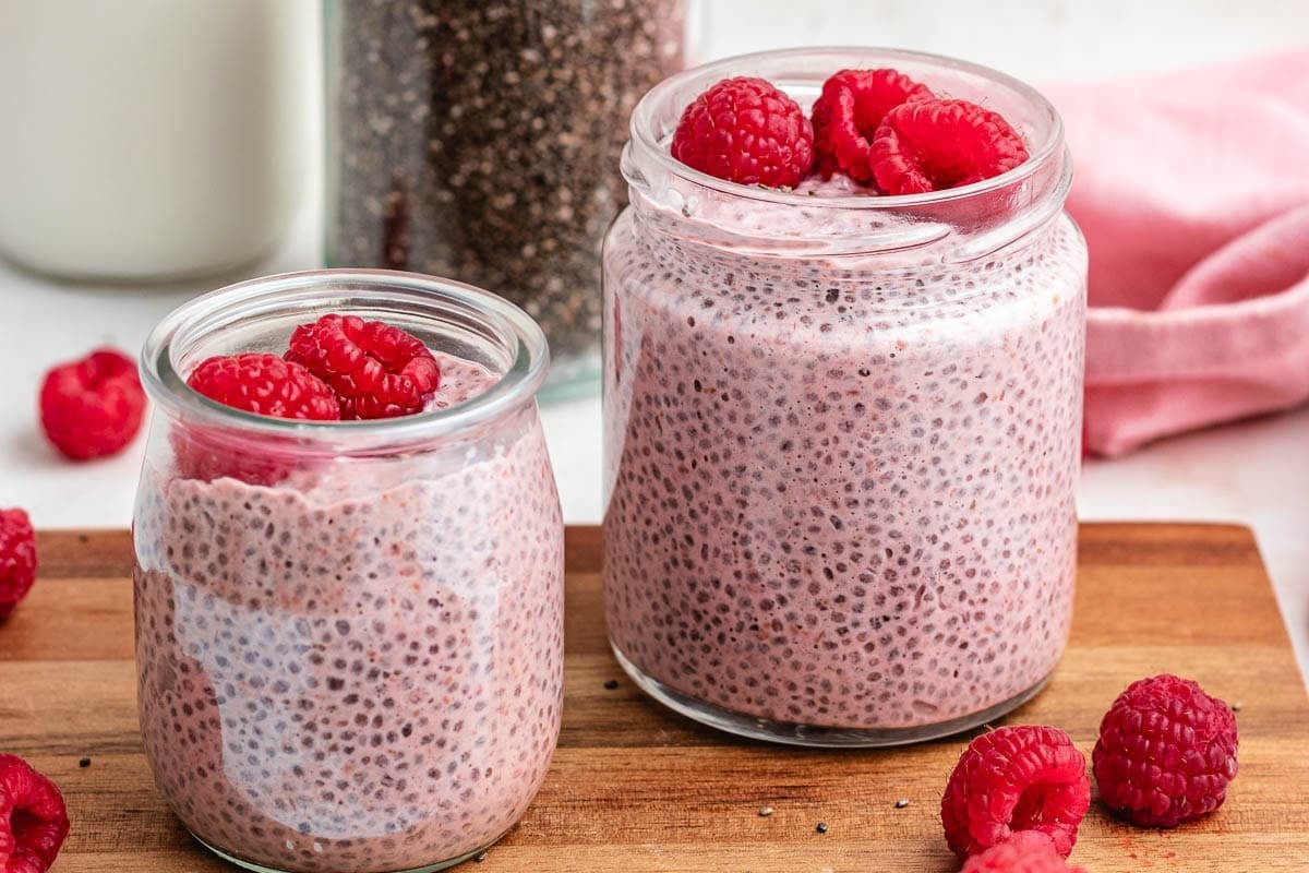 raspberry chia pudding in jars with fresh raspberries. 