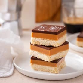 Millionaire shortbread stacked on a white plate.