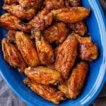 Crispy baked chicken wings on a blue serving dish with the best dry rub