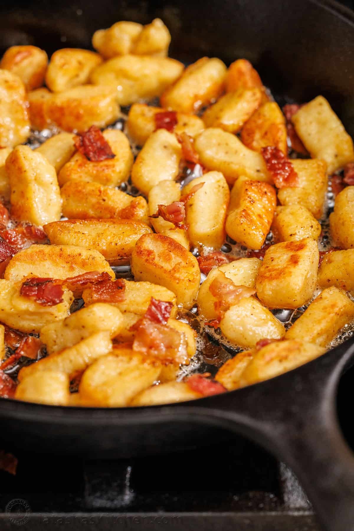Ricotta Gnocchi satisfy the craving for gnocchi with very little effort. No need to fuss with potatoes since the star ingredient is ricotta cheese. browned ricotta gnocchi recipe in a saute pan with bacon