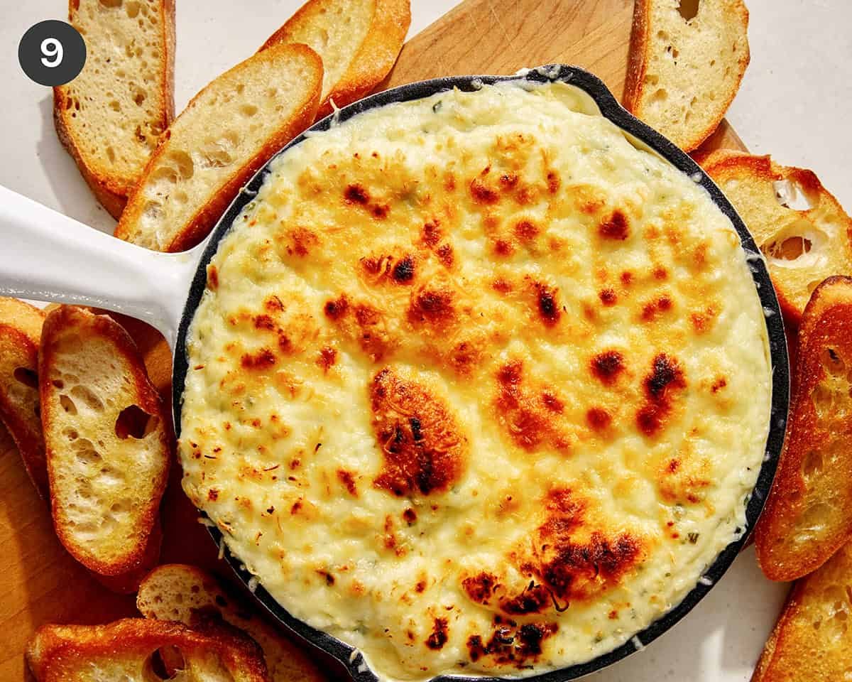 Baked garlic bread dip in a skillet with bread on the side. 