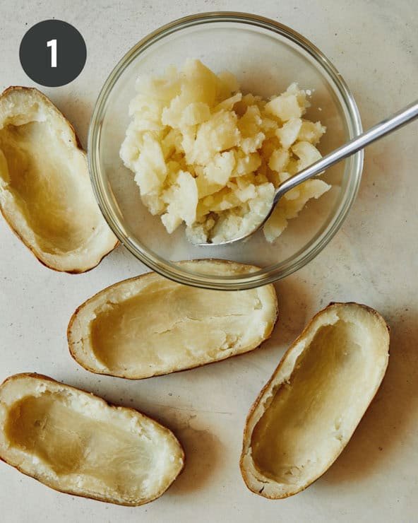 Cooked and hollowed out potato halves shot overhead. 