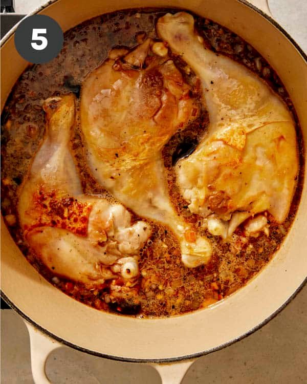 Chicken in sauce in a pot to be braised in the oven. 