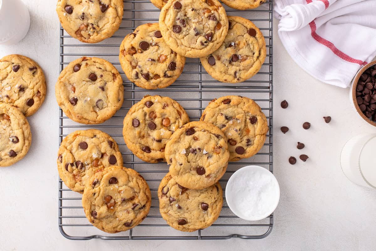 Salted caramel chocolate chip cookies arranged on a wire rack.