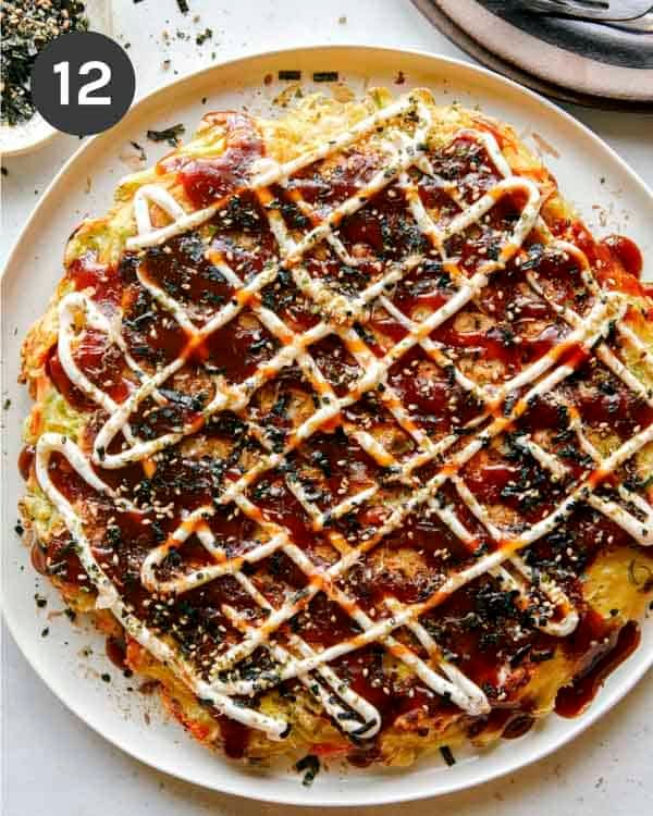 Okonomiyaki on a plate with fork next to it.