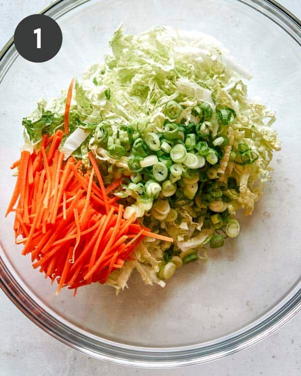 Adding veg to a bowl to make okonomiyaki recipe.