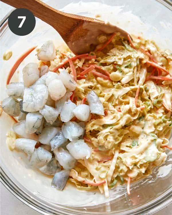 Adding shrimp to okonomiyaki batter.