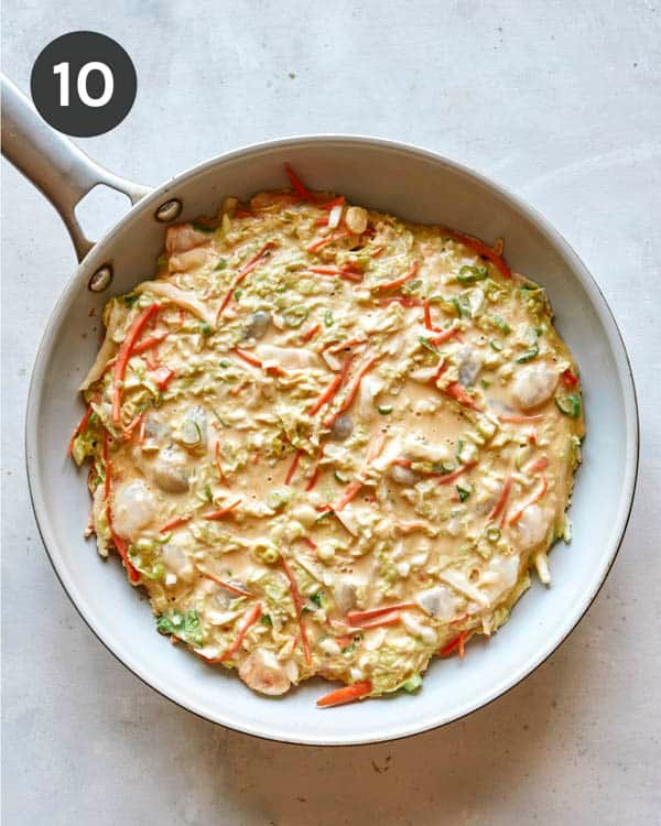 Okonomiyaki pancake batter in an oiled hot skillet.