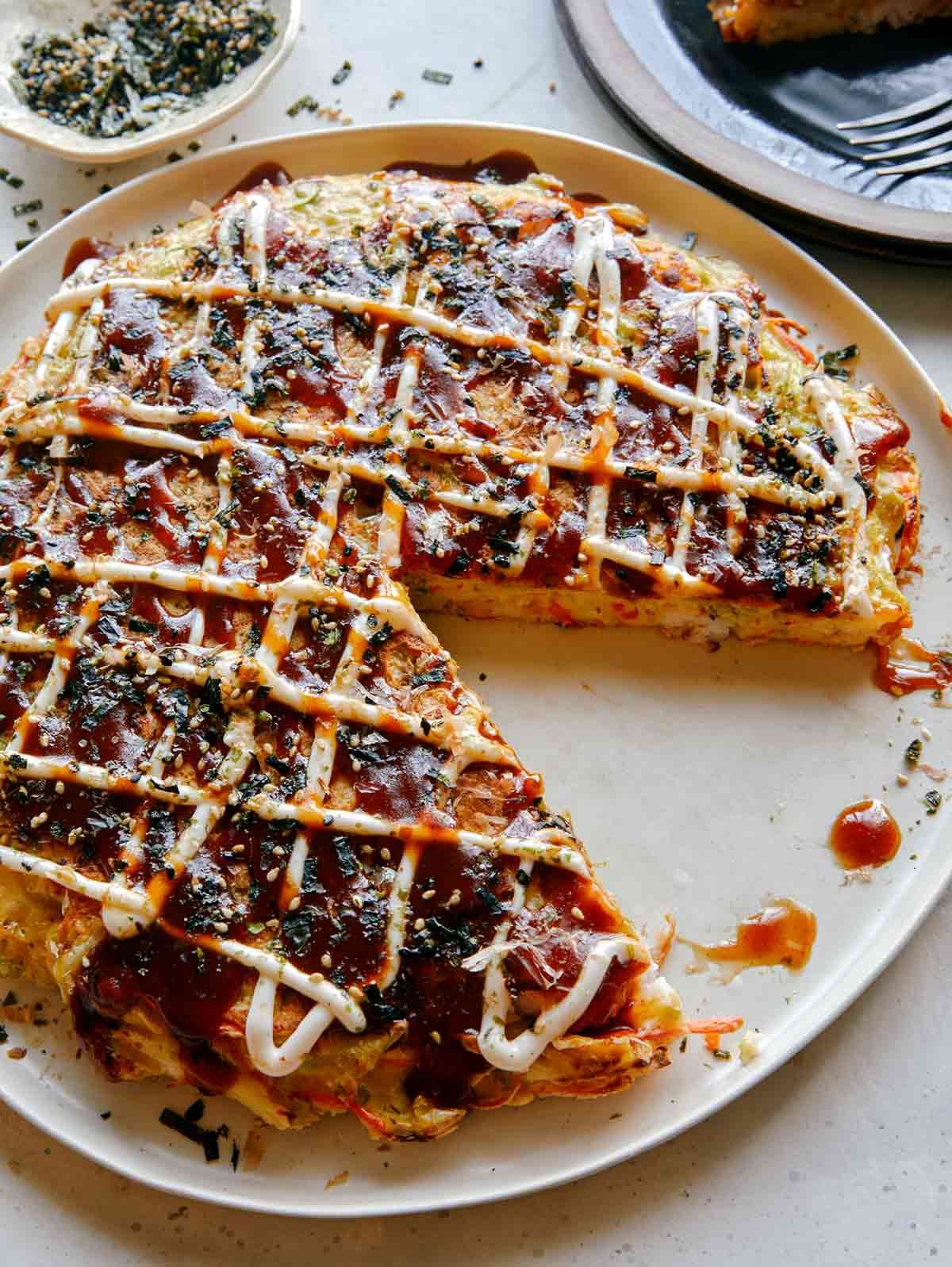 Okonomiyaki on a place with a slice out.