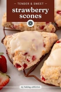 Close up of glazed strawberry scones on a wire rack. Text overlay includes recipe name.
