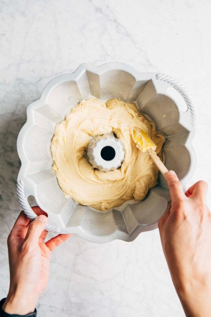 photo of michelle pouring the first layer of condensed milk batter into the bundt pan
