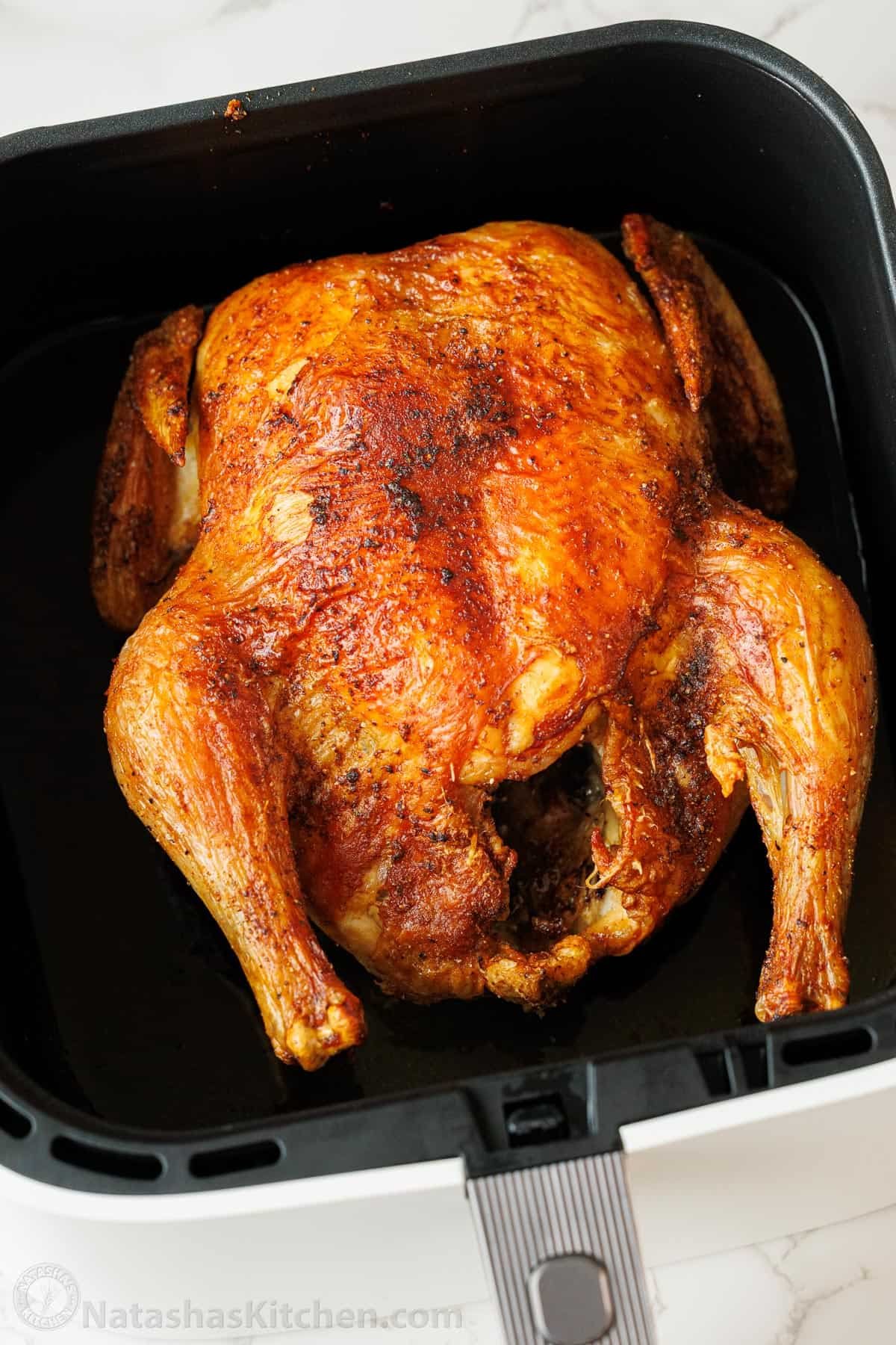 My Air Fryer Whole Chicken Recipe perfectly cooks a 3.5-5.5 pound bird with crispy skin and juicy meat. It's easy and perfectly seasoned. browned whole chicken in the air fryer