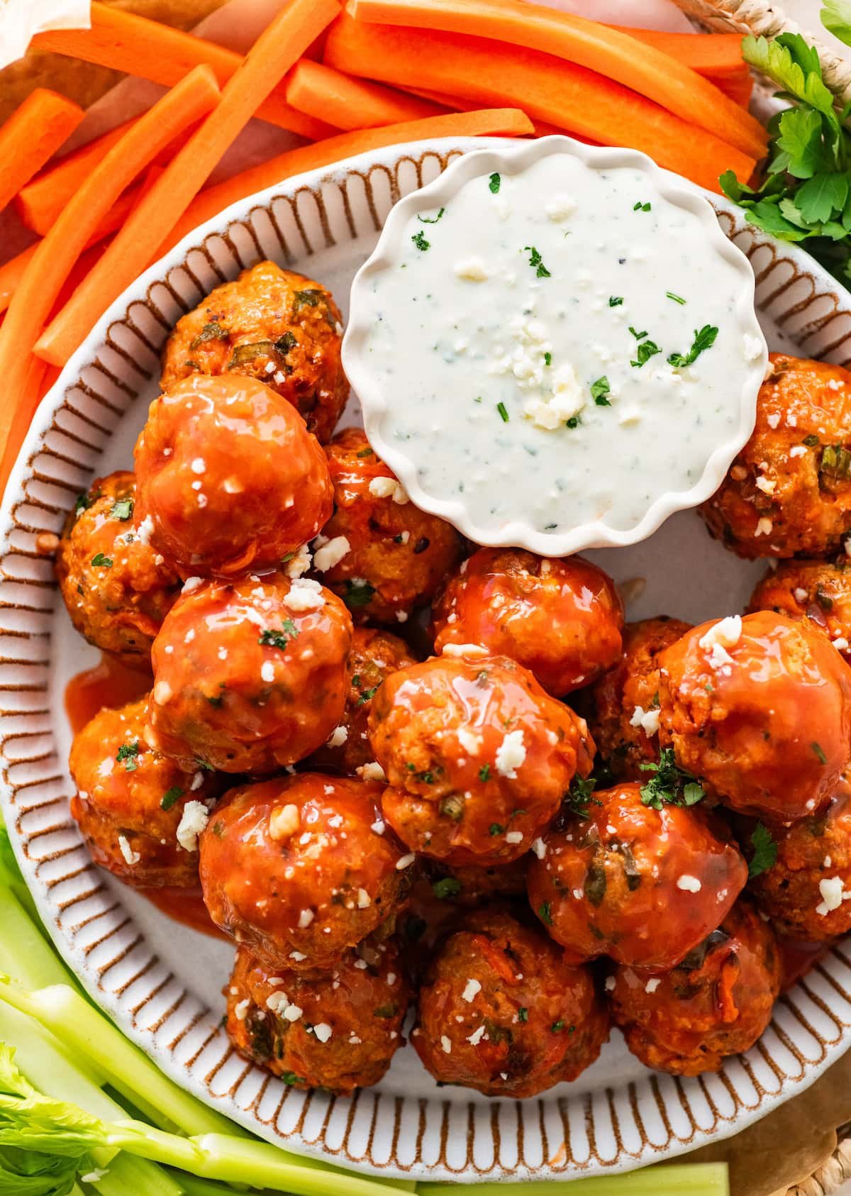 buffalo chicken meatballs on platter with blue cheese dip and cut up vegetables.