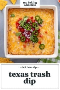 Overhead view of baked texas trash dip in a white baking dish, topped with diced tomato, red onion, and sliced jalapeños. Text overlay includes recipe name.