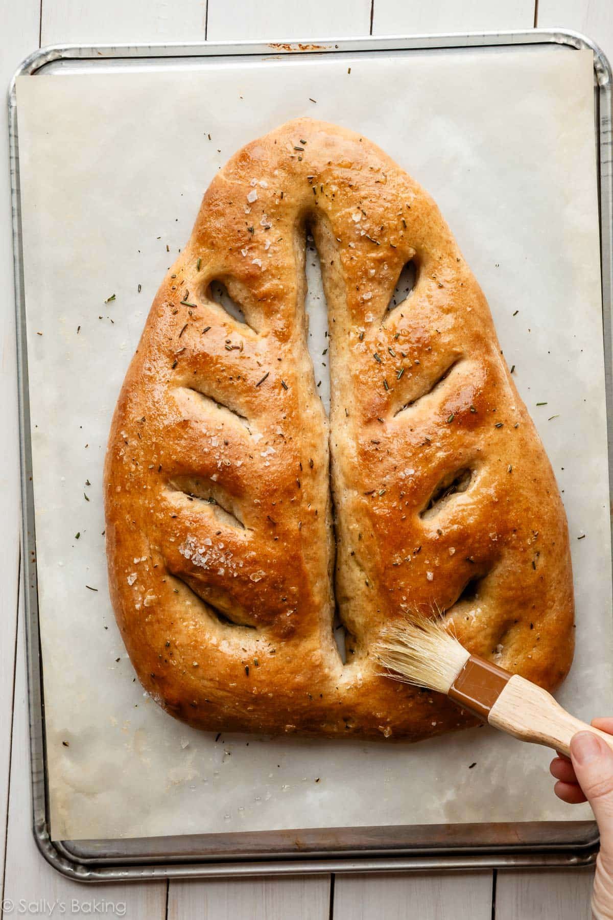 french flatbread being brushed with olive oil.