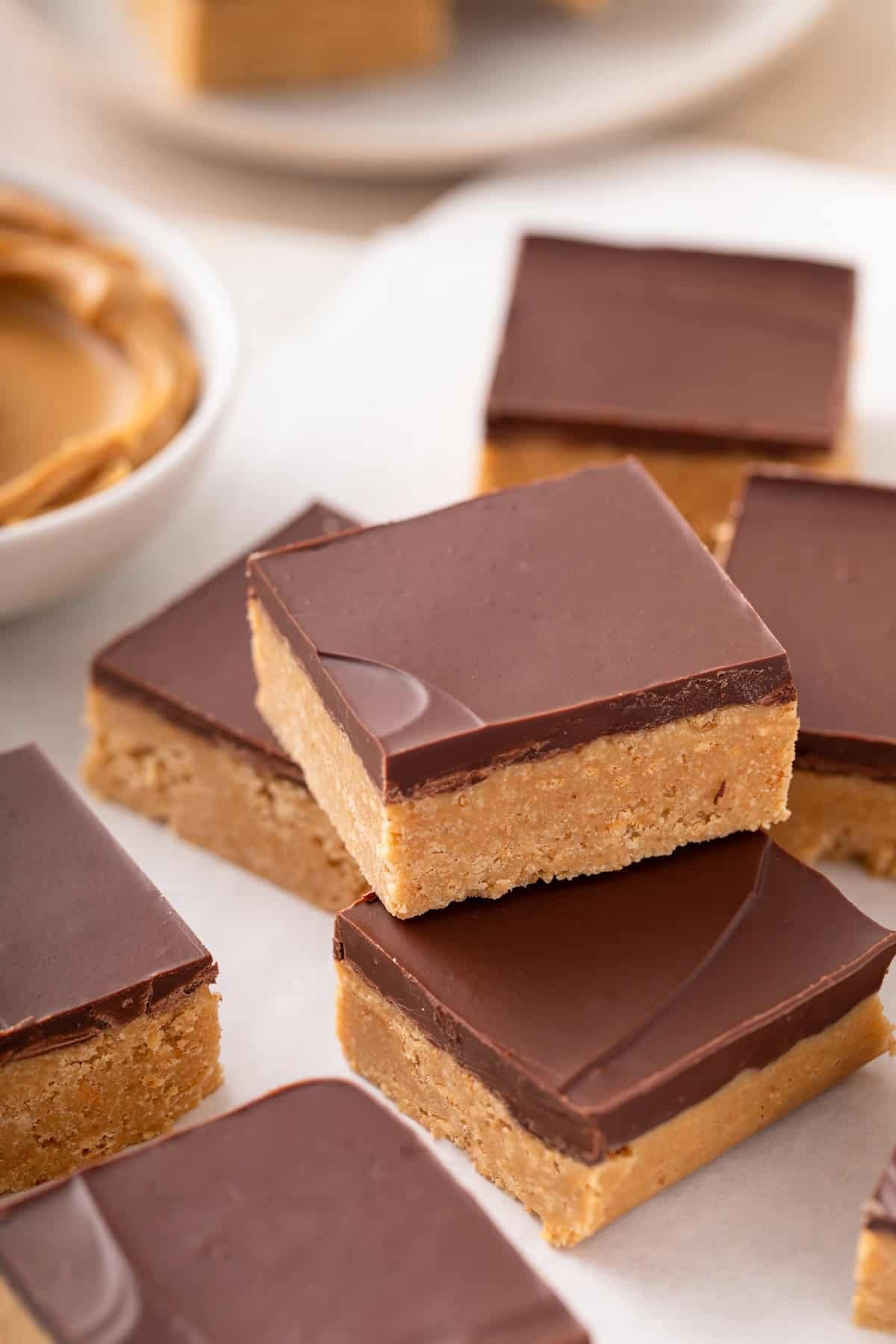 Lunch lady peanut butter bar stacked on top of two other bars on a piece of parchment paper.