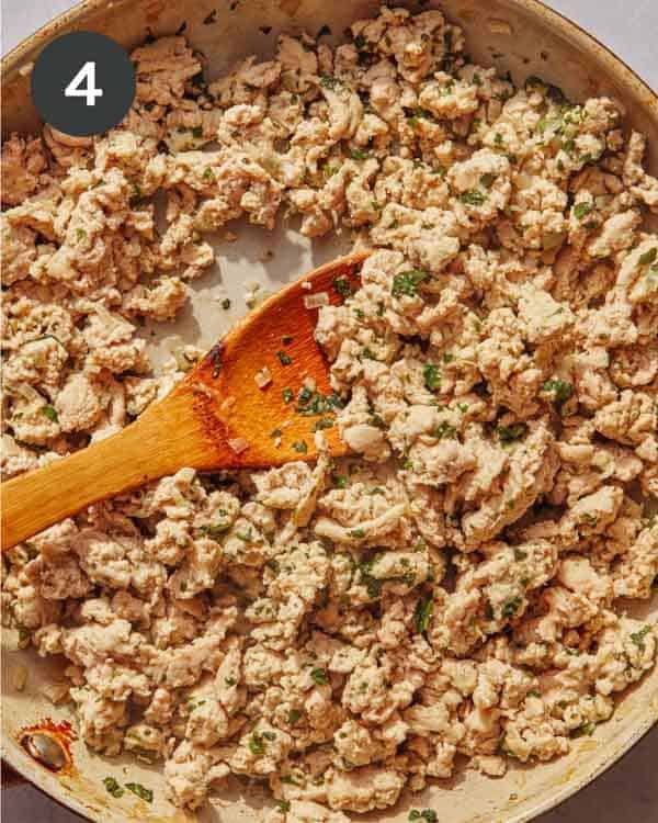 Ground turkey and some seasoning in a skillet being cooked.