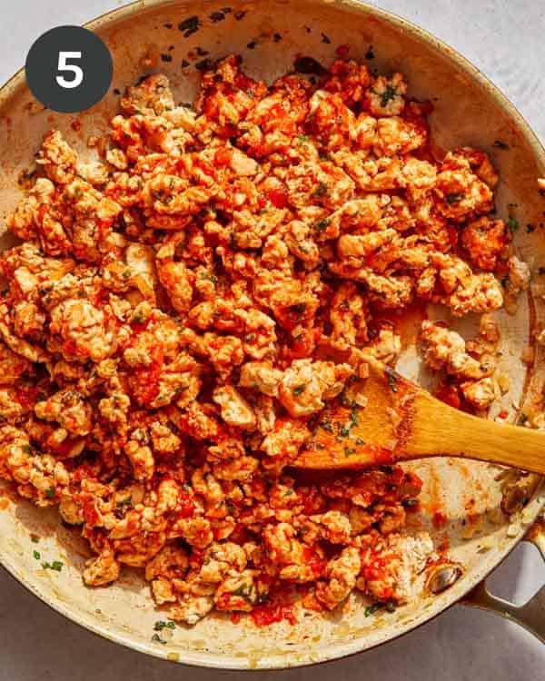 Ground turkey and marinara mixed in a skillet cooking together.