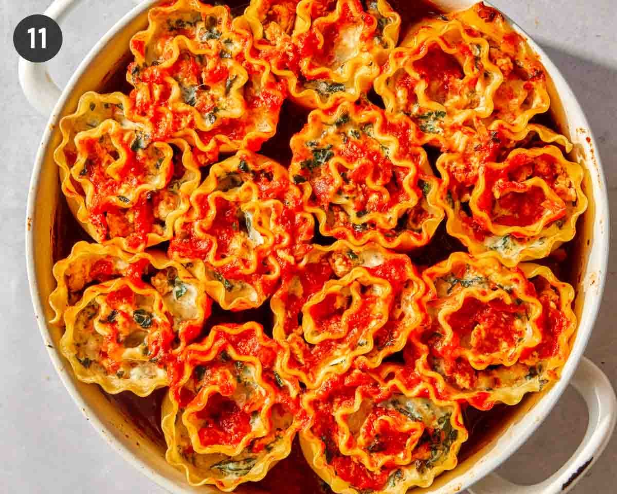 Baked lasagna roll ups in a baking dish.