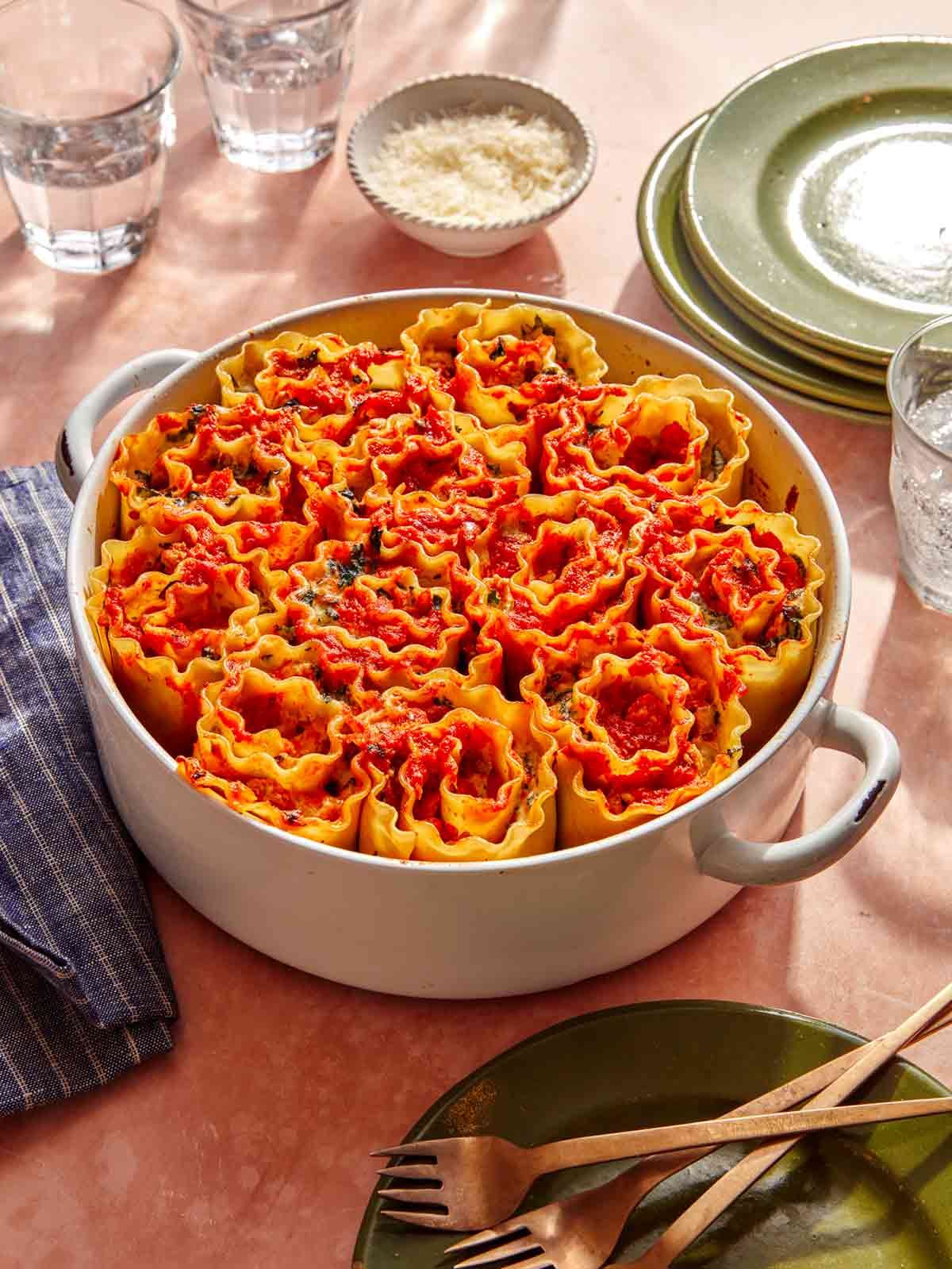 Lasagna roll ups in a baking dish about to be served.