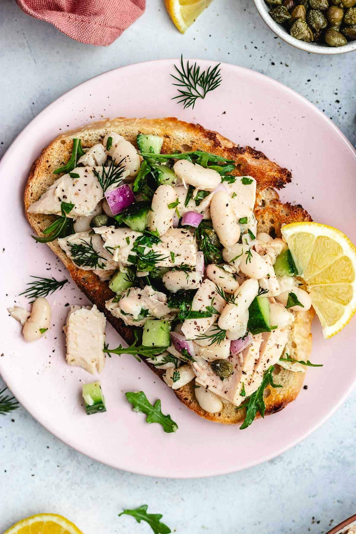 tuna white bean salad on toast on plate. 