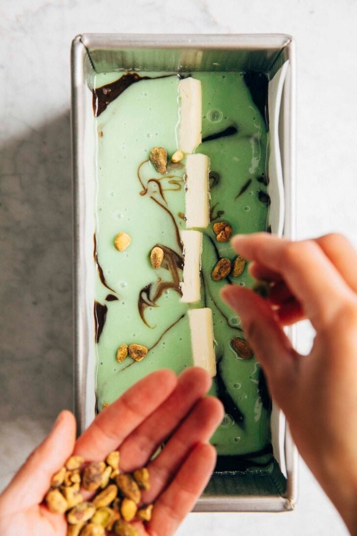 Photo of Michelle garnishing the top of the cake with pistachios
