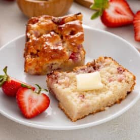 Plated halved strawberry biscuit topped with butter.
