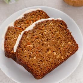 Two slices of carrot cake bread on a white plate.