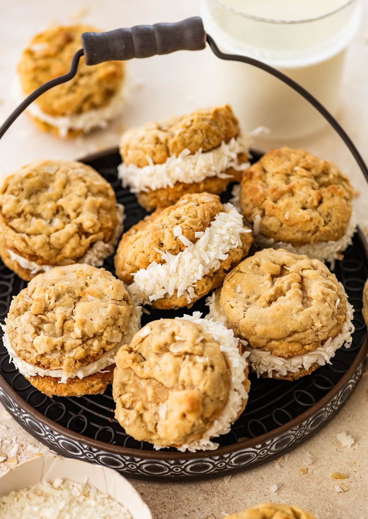 coconut oatmeal cream pies in serving platter with glass of milk. 