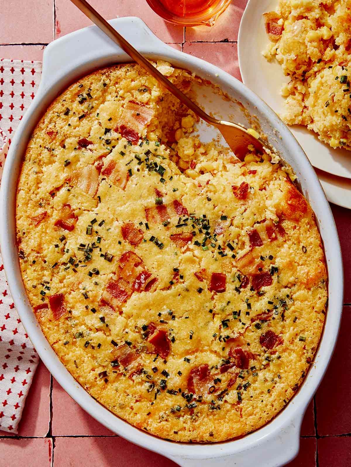 Corn casserole recipe prepared with a scoop taken out.