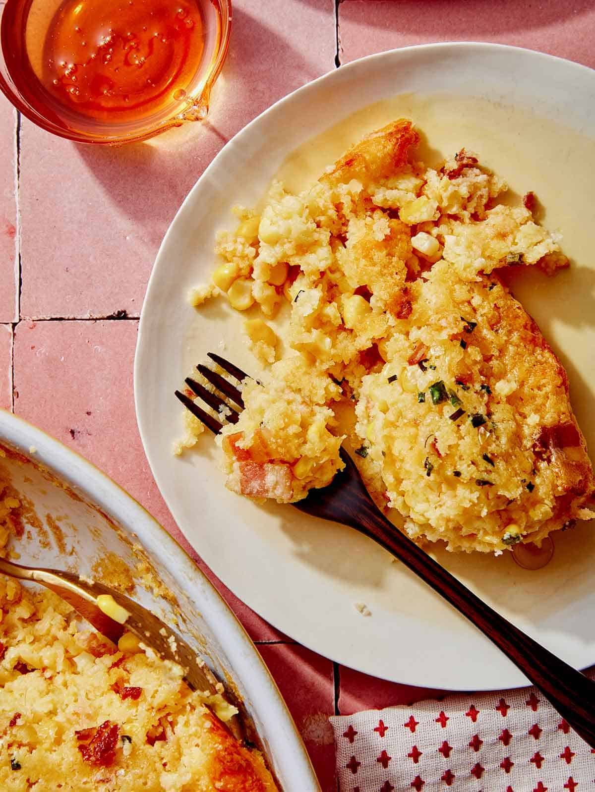 Corn casserole on a plate with a fork.
