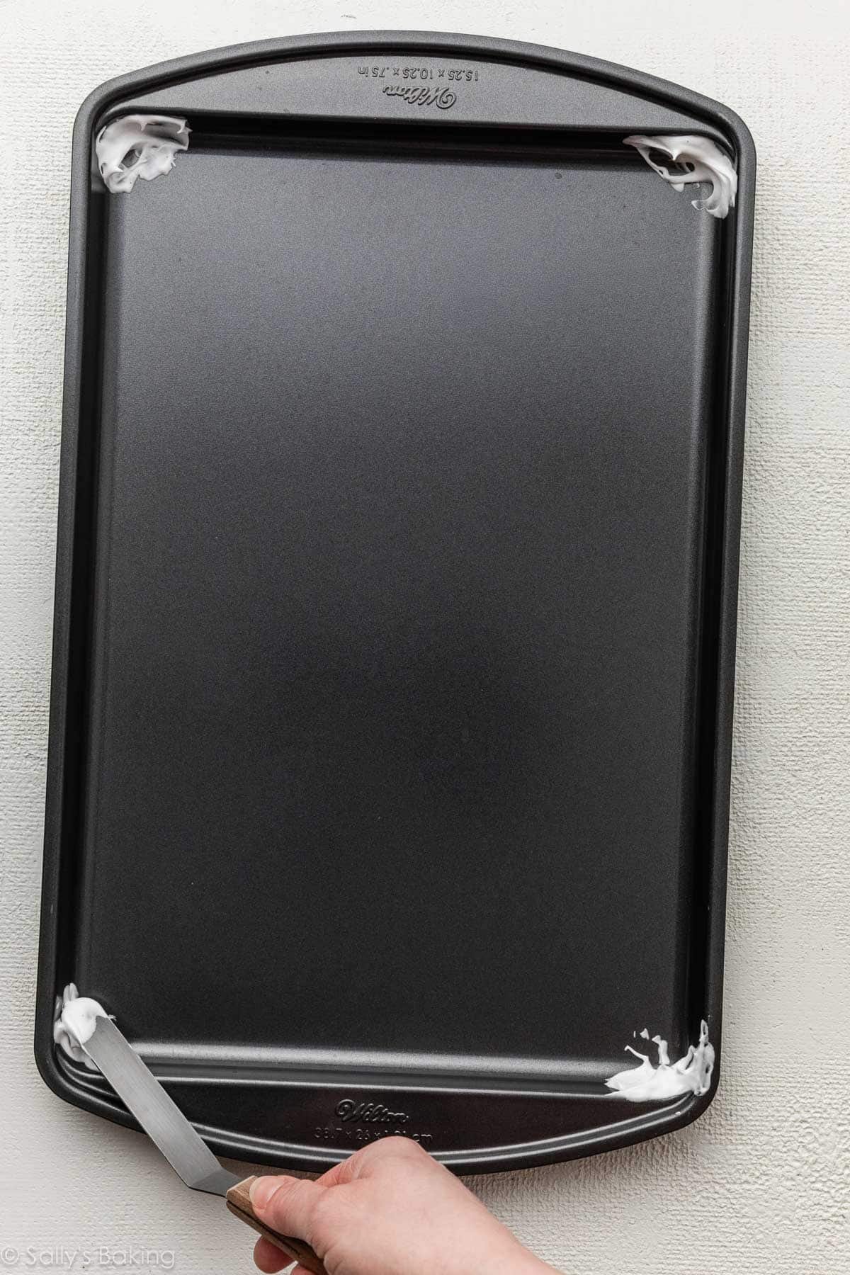 spreading mixture onto corners of pan.