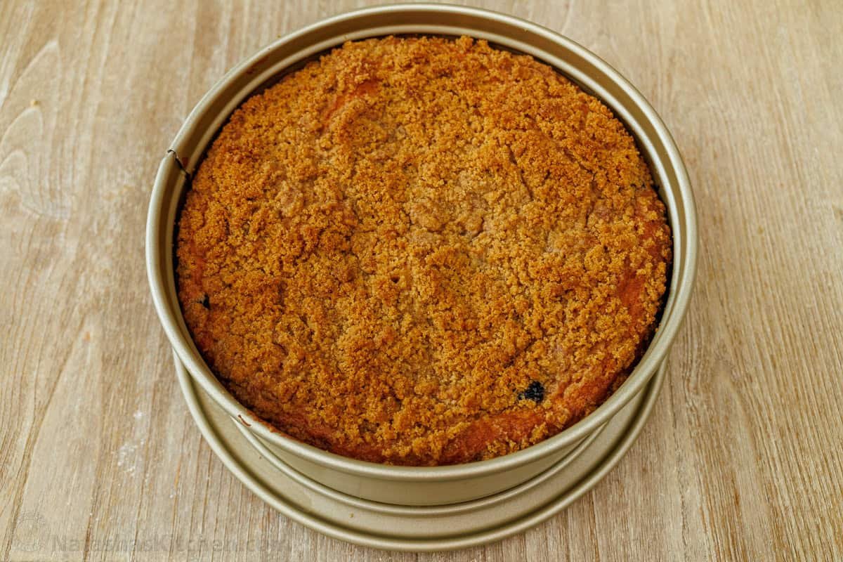 Blueberry coffee cake with crumb topping baked in a round baking pan