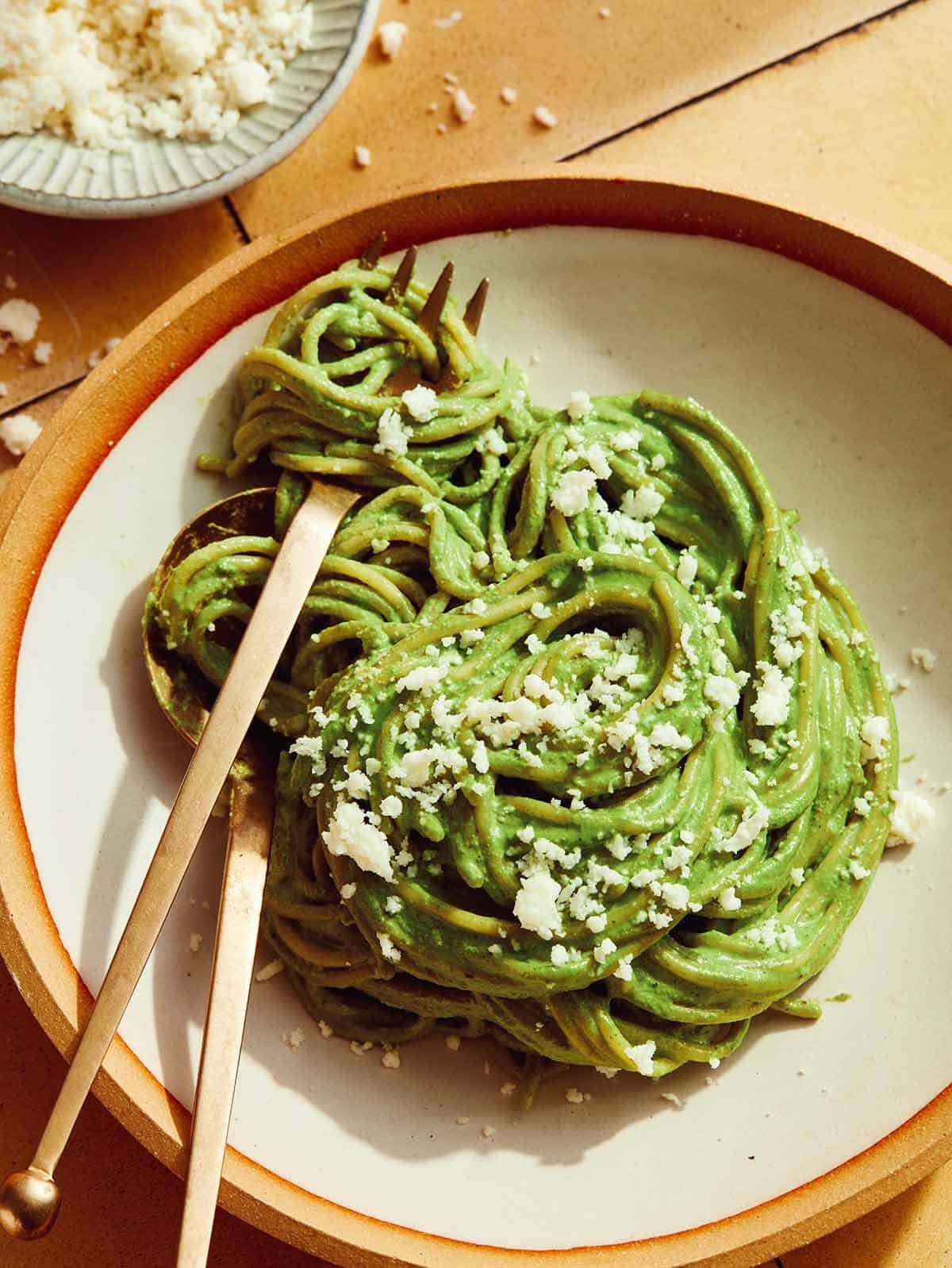 An overhead shot of Tallarines Verde in a bowl with a fork in it.