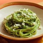 Tallarines Verde recipe in a bowl close up with some queso fresco sprinkled on top.
