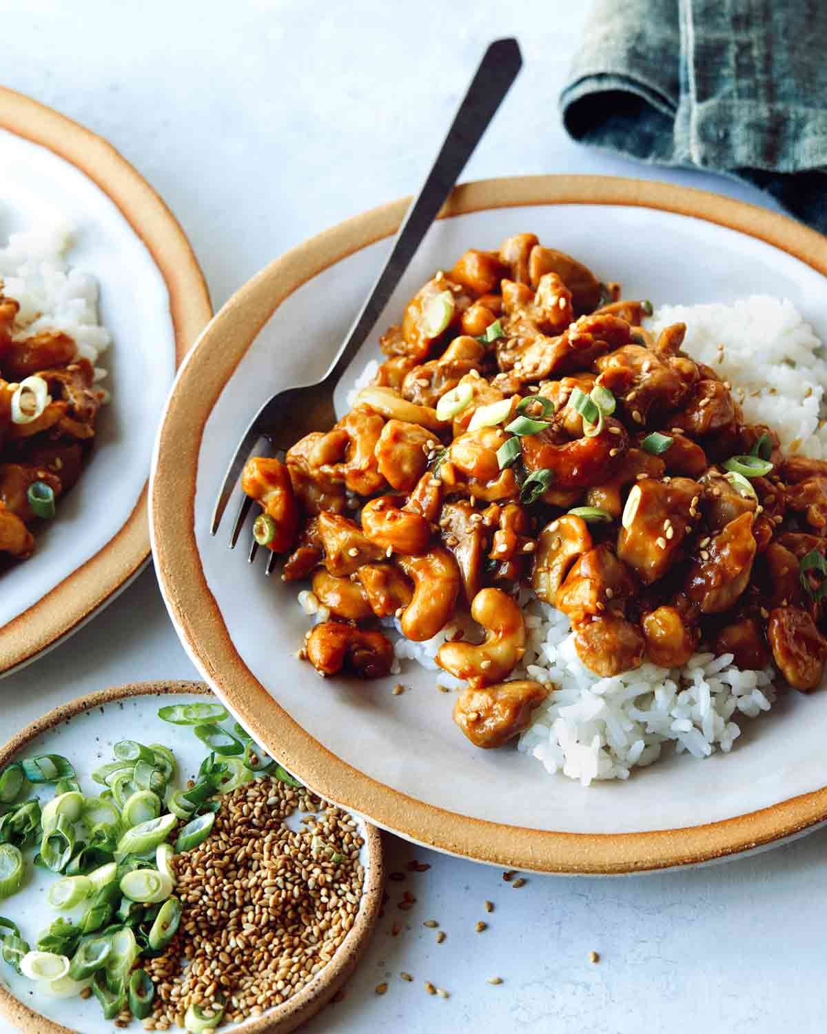 Cashew chicken on two plates with rice.