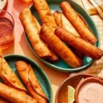 Flautas freshly made in some bowls with a dipping sauce on the side.